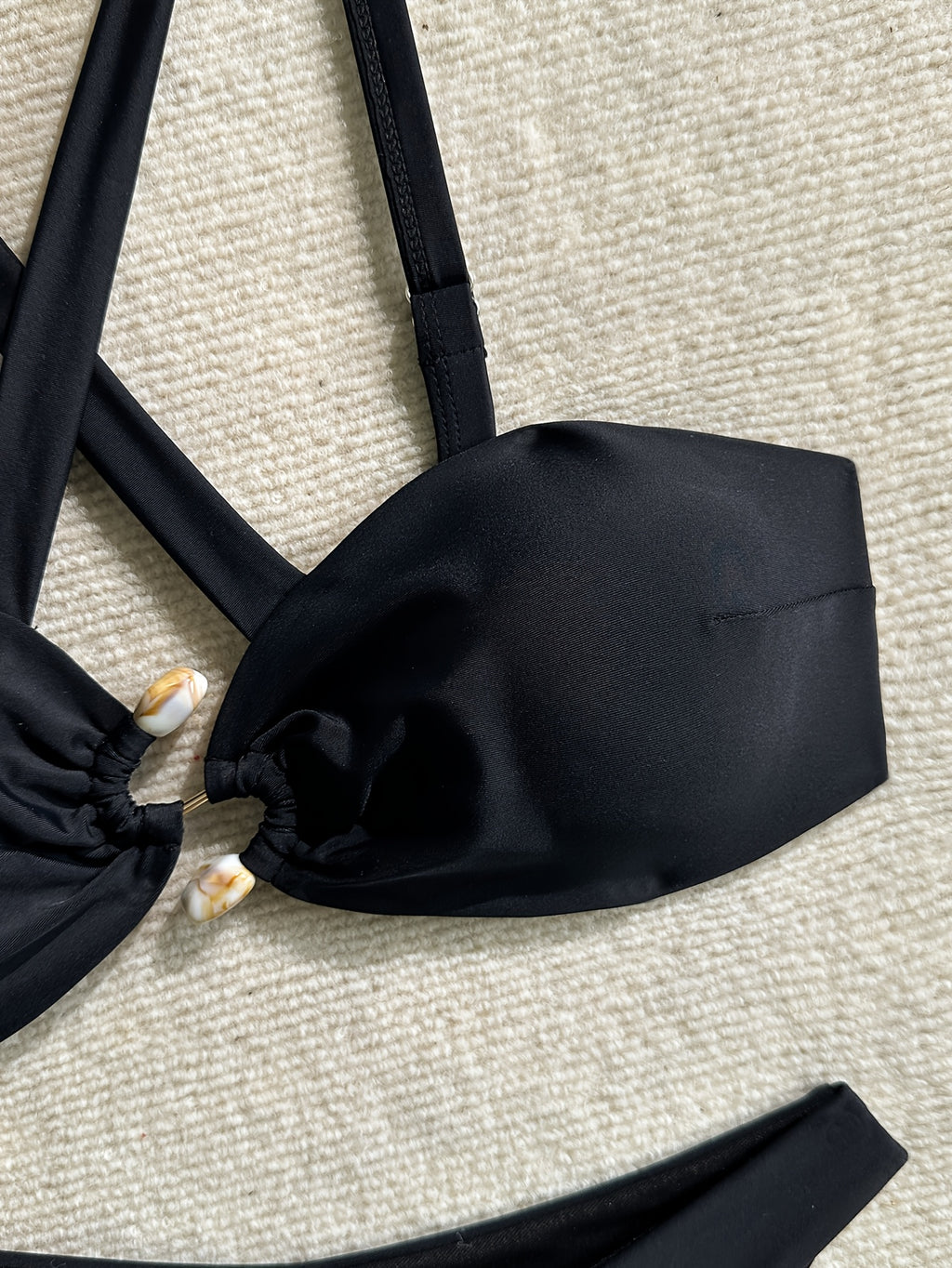 Bikini negro con tiras cruzadas y decoración metálica