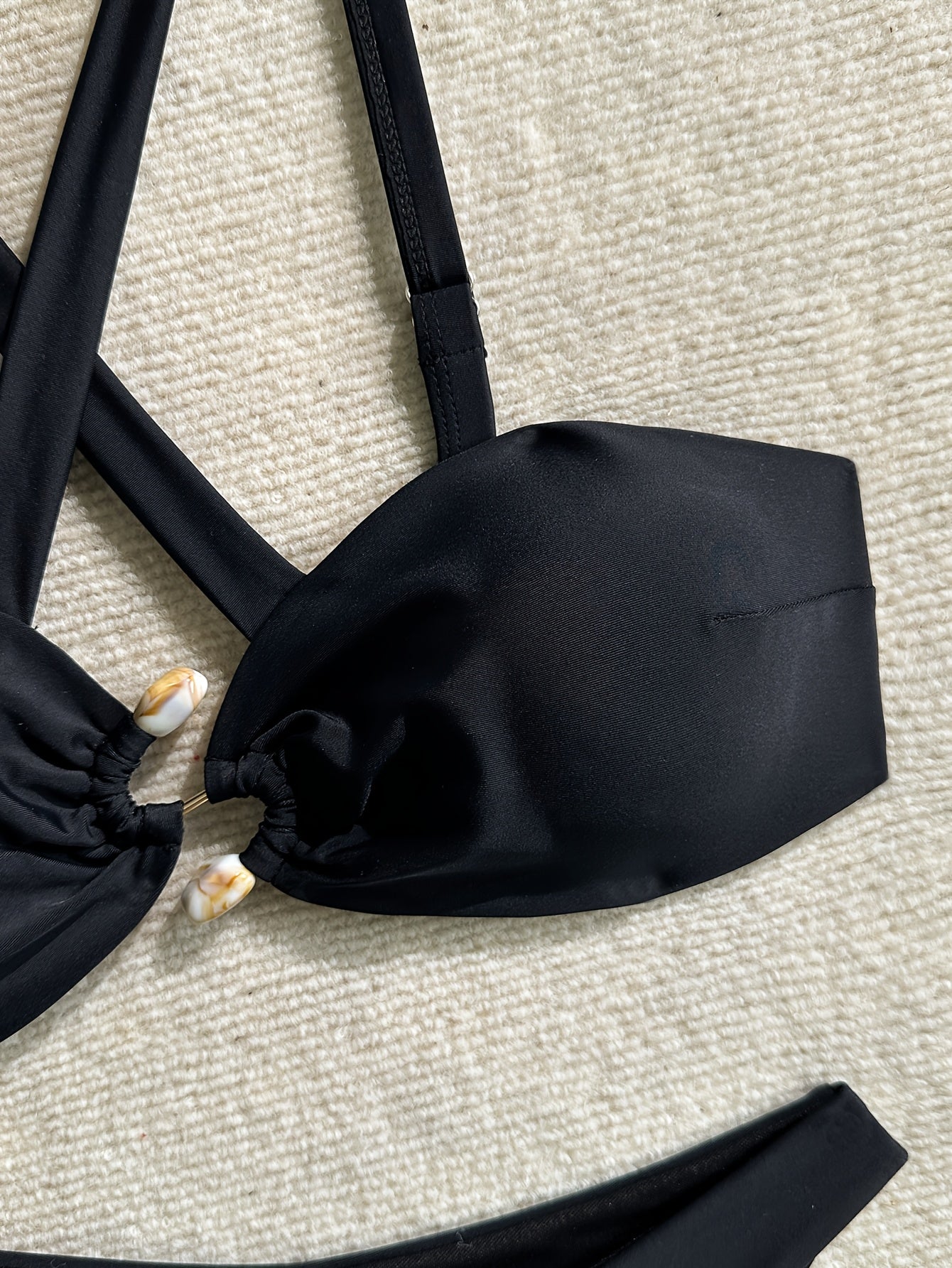 Bikini negro con tiras cruzadas y decoración metálica