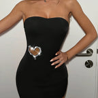 Vestido ajustado con detalle de corazón de pedrería brillante.